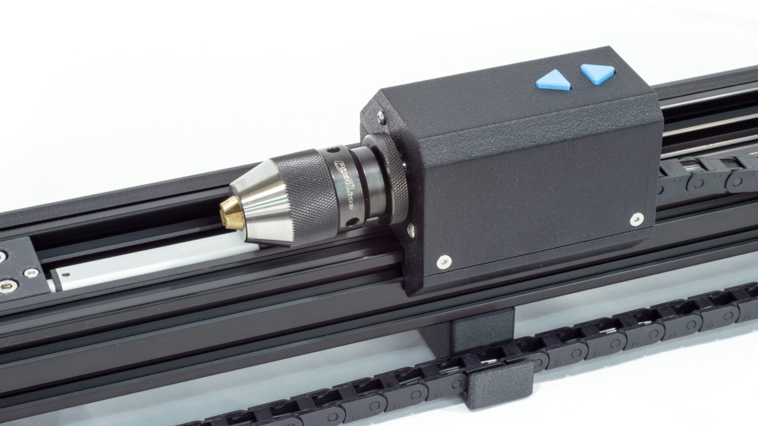 Sub spindle on bench top coil winder. The sub spindle has a keyless 3 jaw chuck and two blue buttons on top to move it left and right for mandrel tensioning.