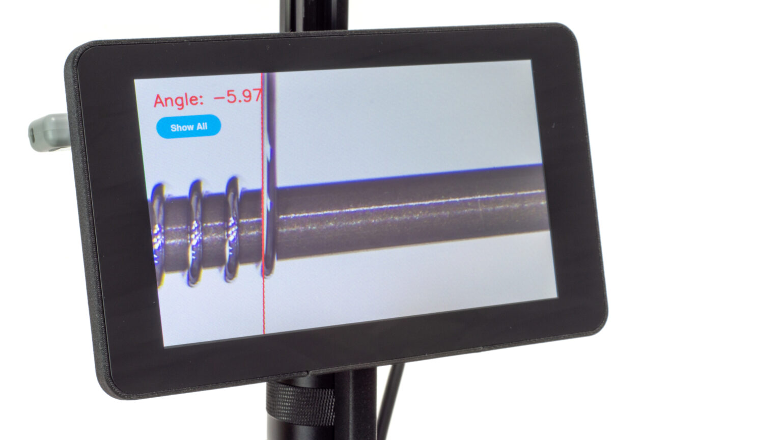 Video microscope showing magnified view of coil being wound over a mandrel. The winding angle is being measured and displayed on screen using computer vision of the edge of the wire.